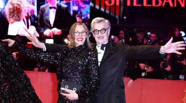 СОПРУГАТА НА ВИМ ВЕНДЕРС НОСЕШЕ ФУСТАН ОД ВИДЕОЛЕНТИ ОД НЕГОВИ ФИЛМОВИ НА ОТВОРАЊЕТО НА БЕРЛИНАЛЕ